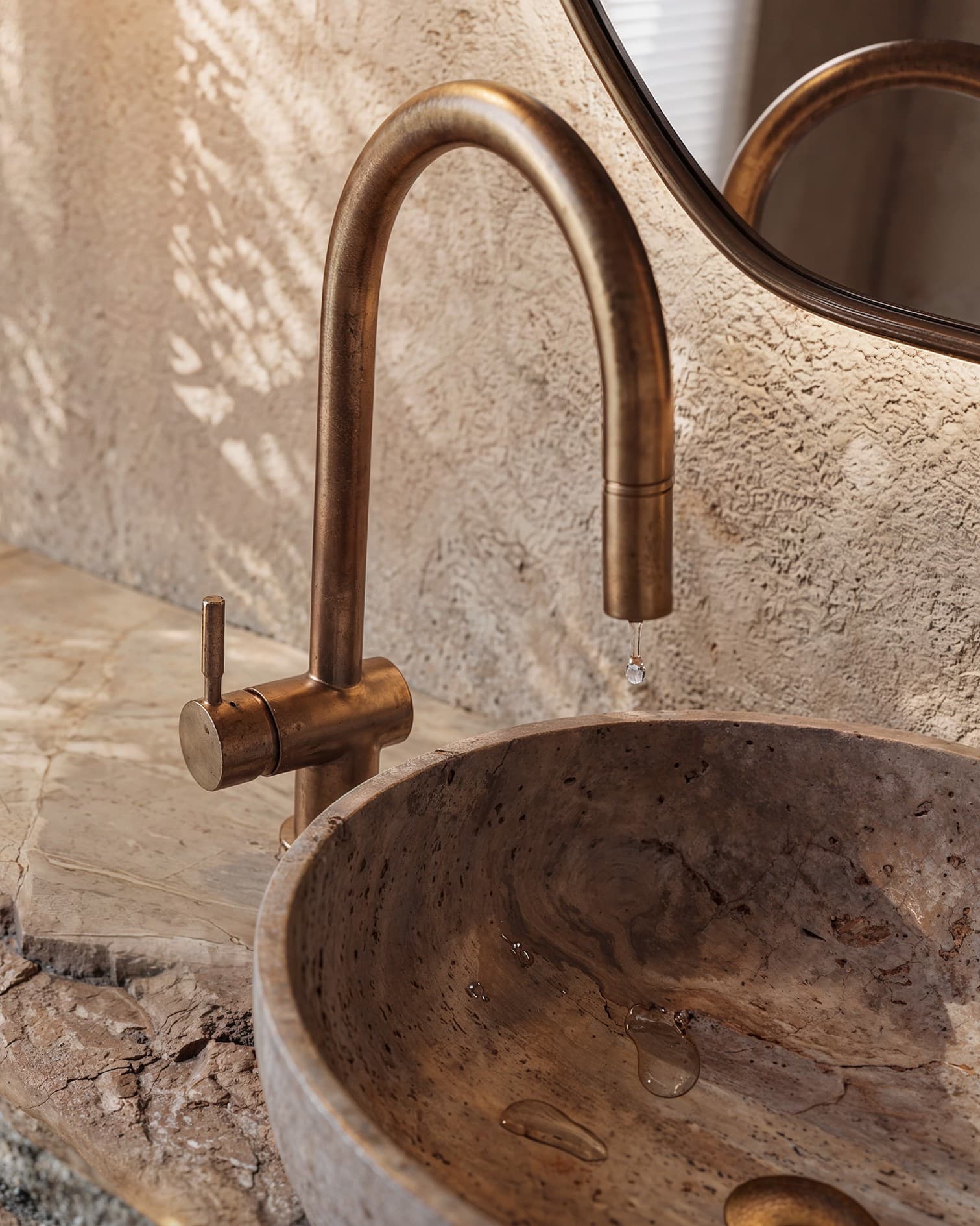 Visualización CGI de un lavabo de piedra y grifería metálica iluminados por luz natural